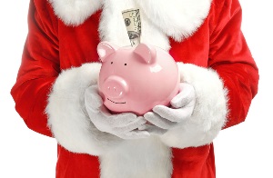 Santa Claus holding piggy bank with banknote on white background