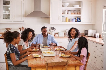 Family With Teenage Children Eating Meal In Kitchen