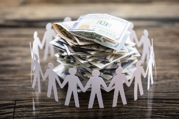 Paper Cut Out Human Figure Surrounding Stacked Banknotes