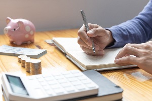 Man are taking notes on household income and expenses and working to save money for future use