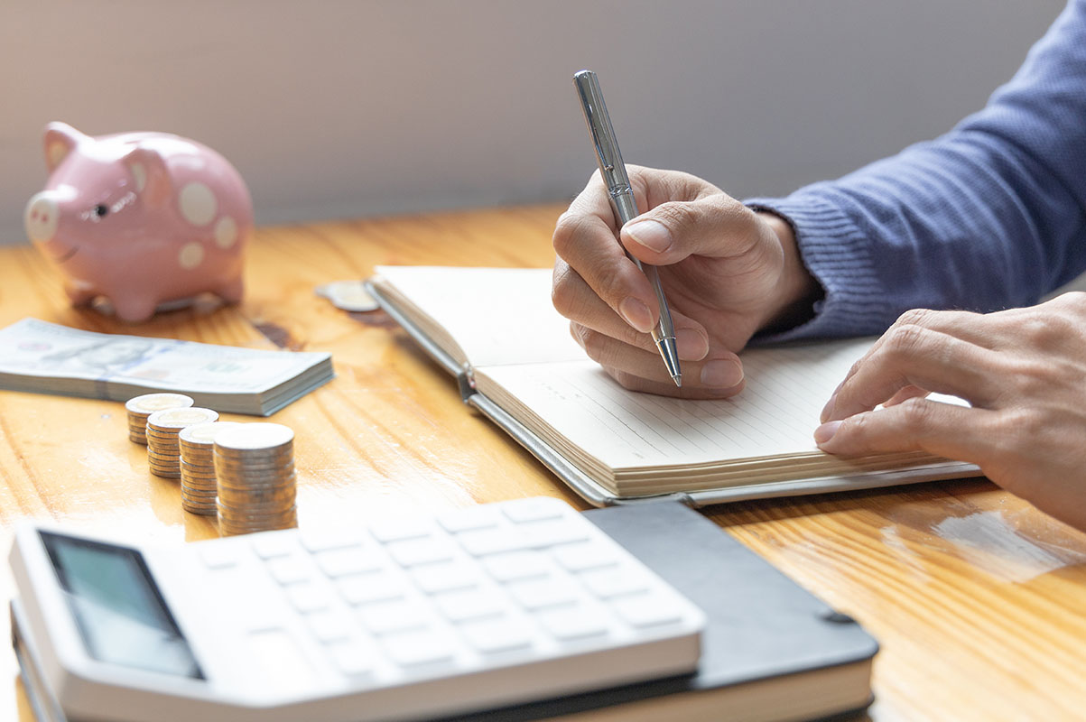 Man are taking notes on household income and expenses and working to save money for future use