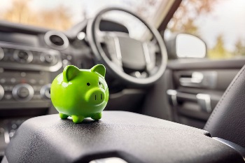 Green piggy bank sitting on car consul