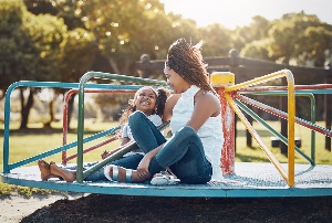 Adult woman and child sitting on merry-go-round