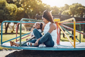 Adult woman and child sitting on merry-go-round