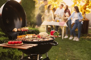 Close up of a grill and people standing in the background
