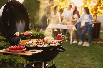 Close up of a grill and people standing in the background