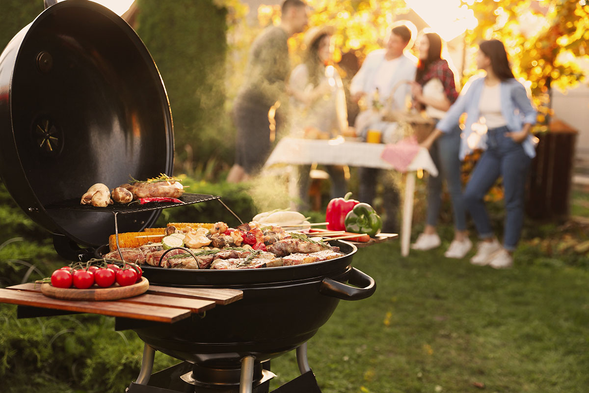 Close up of a grill and people standing in the background