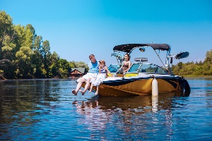 Happy family on a sunny day enjoying their boat in the water.