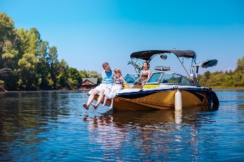 Happy family on a sunny day enjoying their boat in the water.