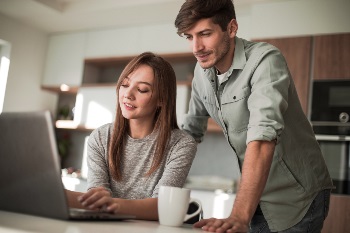 Man and woman looking at a laptop with cup of coffee