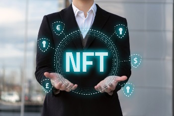 Man in suit with two hands holding up NFT with various symbols around it