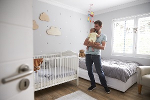 father comforting newborn baby in nursery