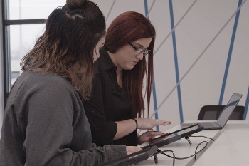 An IHMVCU employee helping a member at a branch