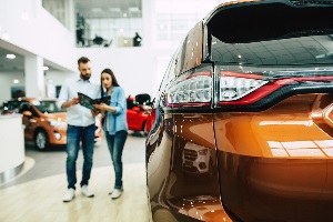 couple looking at new cars at dealership