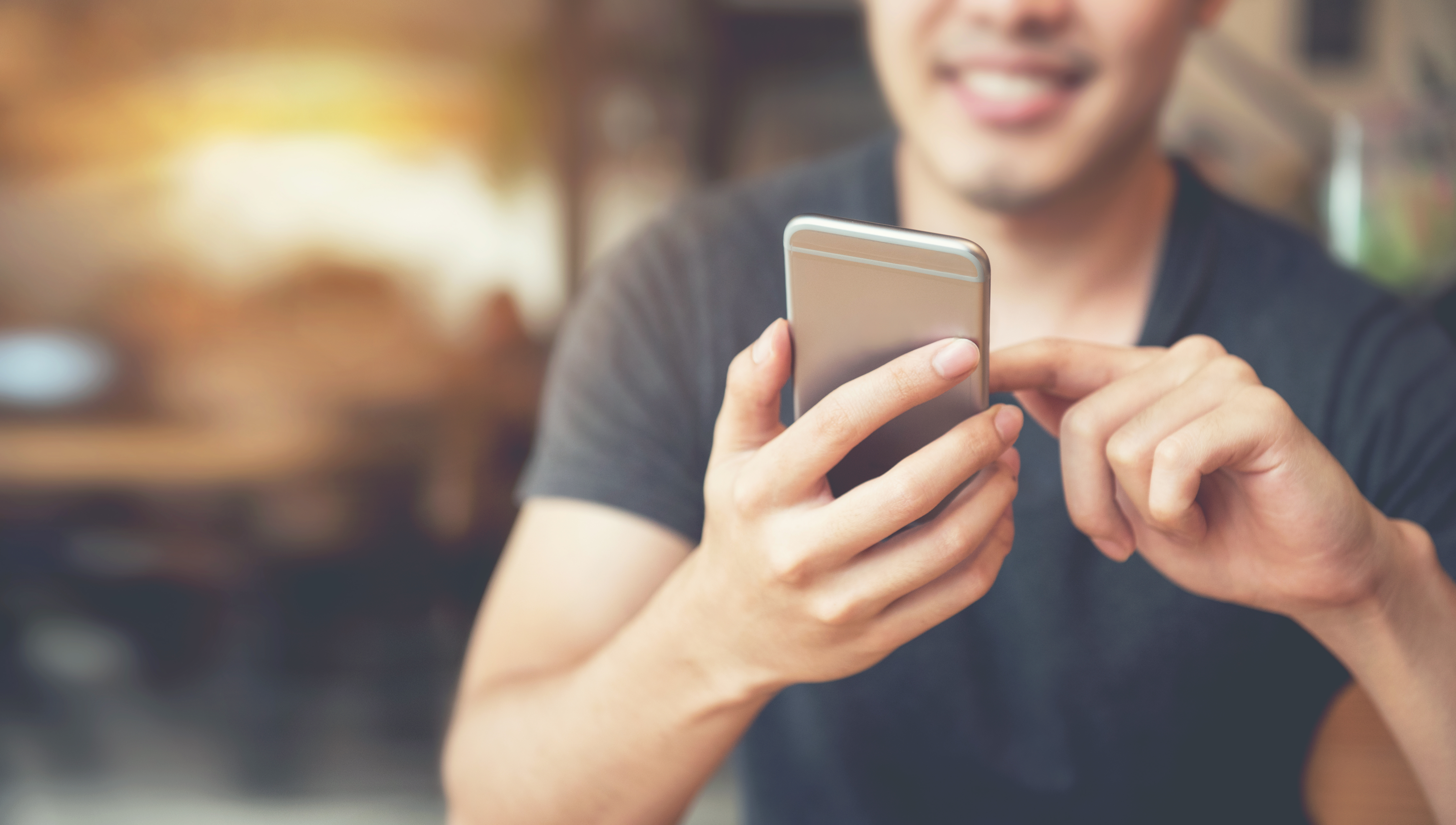 Younger man tapping on his phone