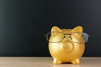 gold piggy bank with glasses on