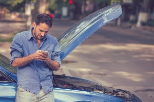 Man on phone with broken down car