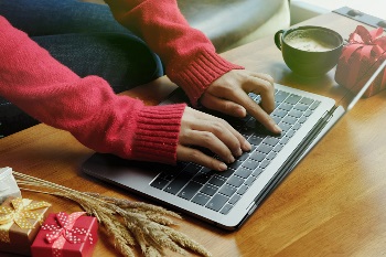 Woman typing on computer for holiday shopping