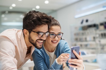 man and women happy looking at phone in store
