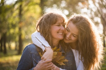 Aging mother and daughter smiling