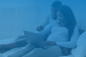 Pregnant woman and partner looking at computer