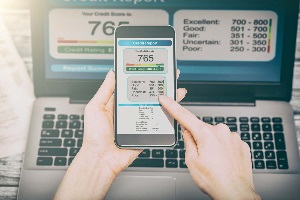 computer and phone with person's credit score up on screen