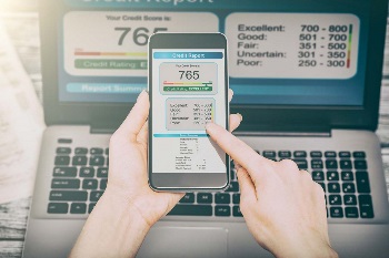 computer and phone with person's credit score up on screen