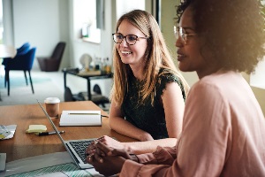 two women with glasses and a laptop talking to advisor two women with glasses and a laptop talking to advisor