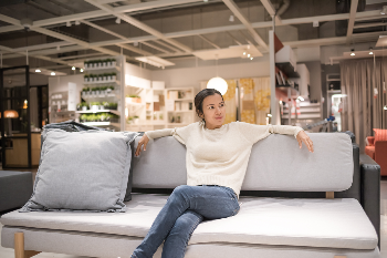Woman sitting on couch inside furniture store