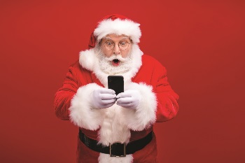 Shocked Santa holding phone.