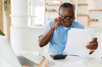 Elderly man looking at bills
