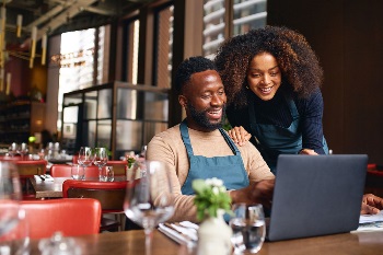 Couple in restaurant looking at laptop