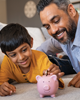 Man and boy putting money in piggy bank