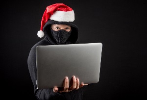 Scammer in black holding laptop Scammer in black holding laptop