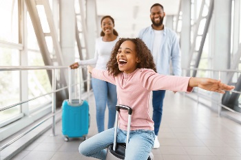Black family at the airport smiling with their bags Black family at the airport smiling with their bags