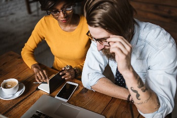 hipster couple learning how to get approved for credit card in coffee shop