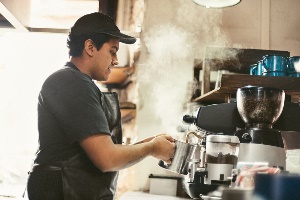 young man working second job as a barista