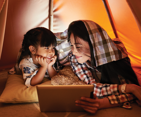 Woman and girl in tent with tablet